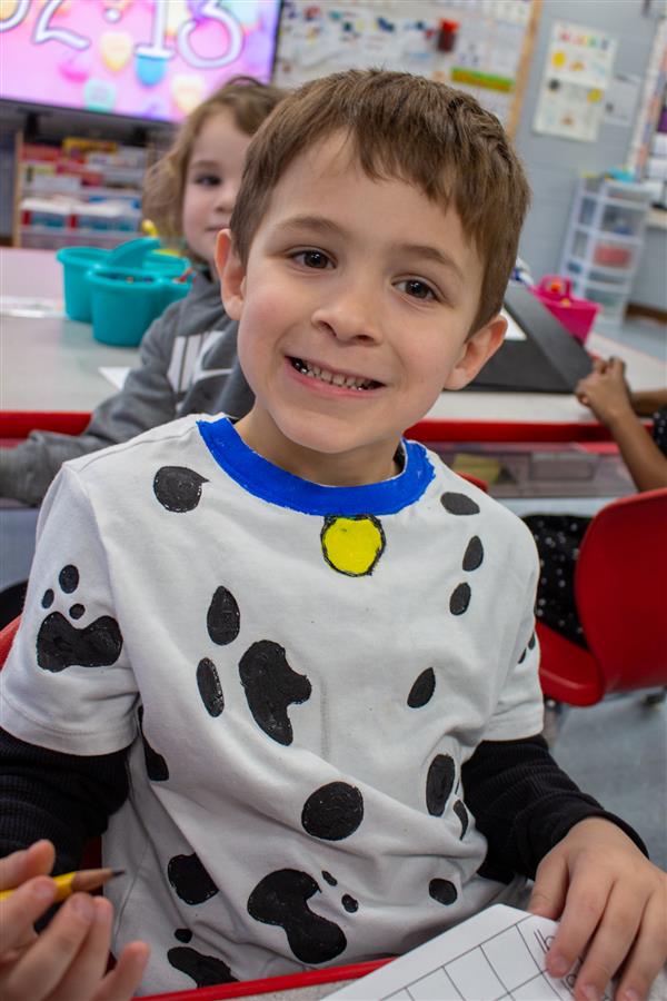 boy smiling dressed as dalmatian dog